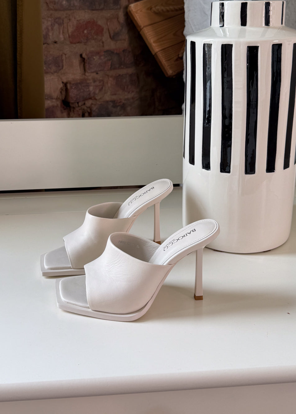 White high-heeled shoes on a white surface