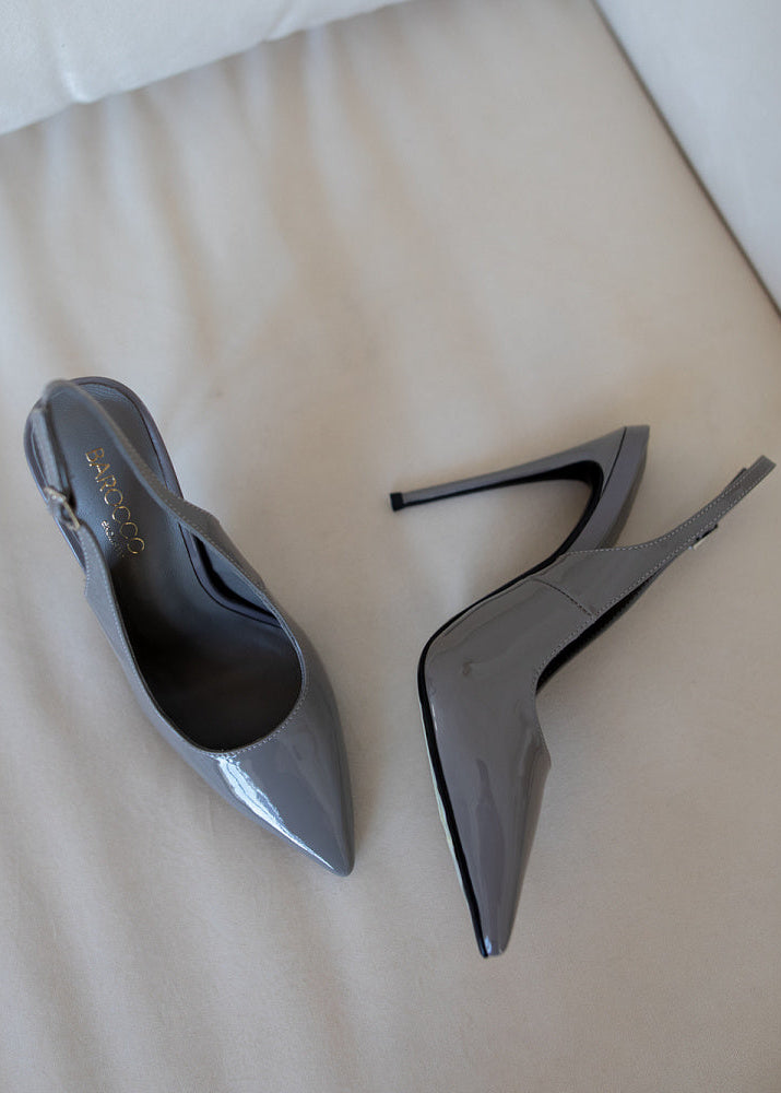 Pair of gray high-heeled shoes on a light-colored surface