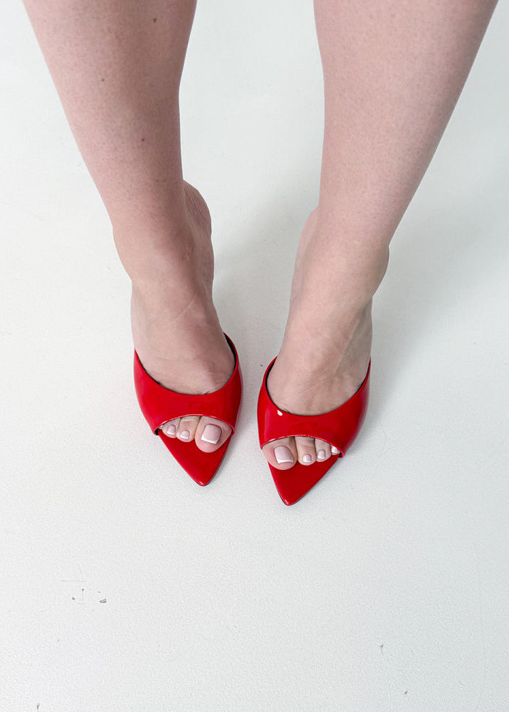 Red high-heeled shoes worn on a white background